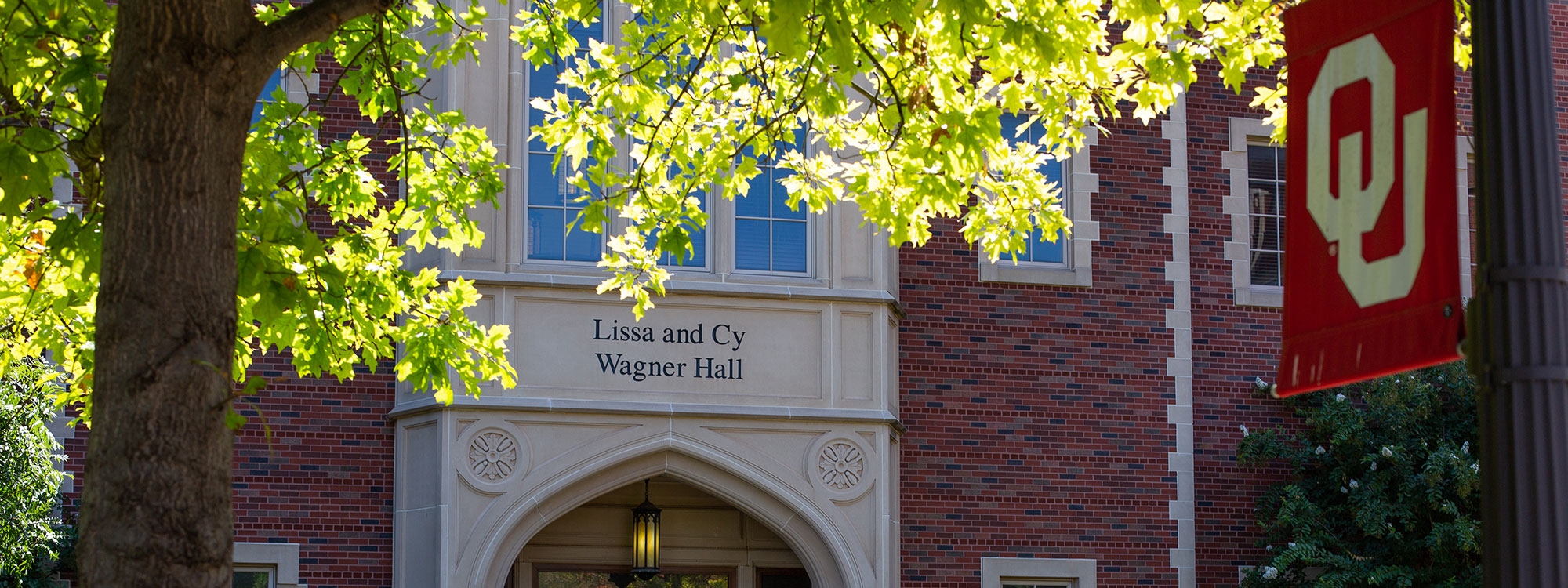 An OU flag in front of Lissa and Cy Wagner Hall.