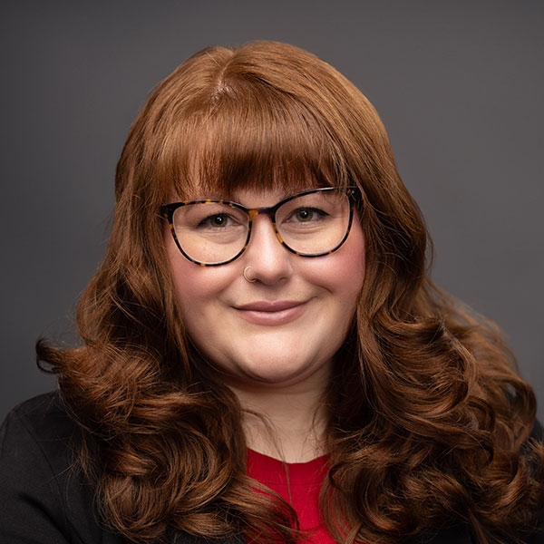 An O U flag on a lamppost, surrounded by greenery.