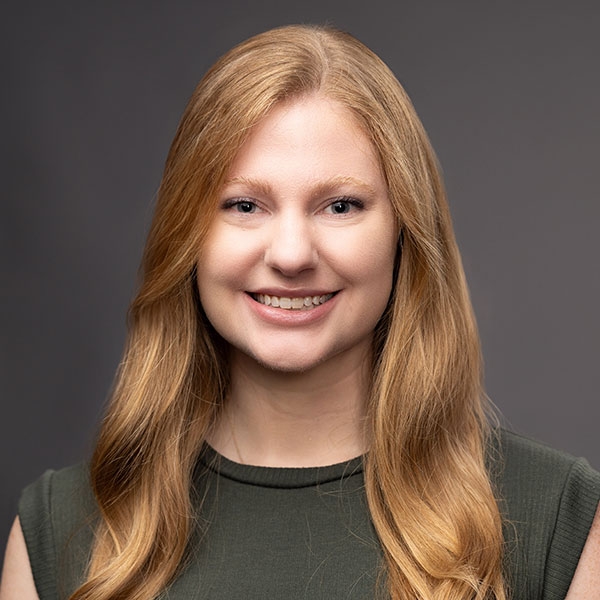 An O U flag on a lamppost, surrounded by greenery.