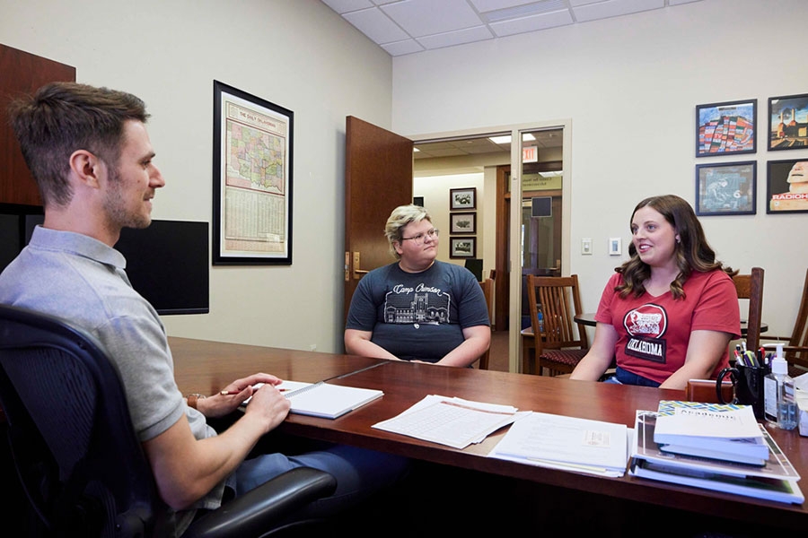 An advisor meeting with students in his office.