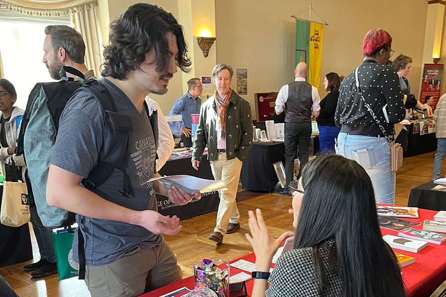 A student at  a career fair talking to someone behind a booth.