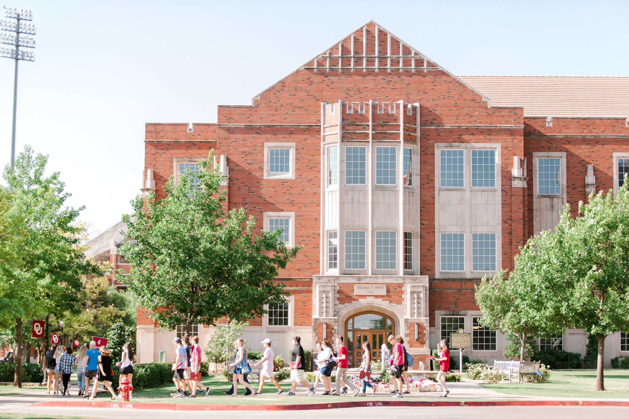 Group of students walking past Adams Hall during New Sooner Orientation 