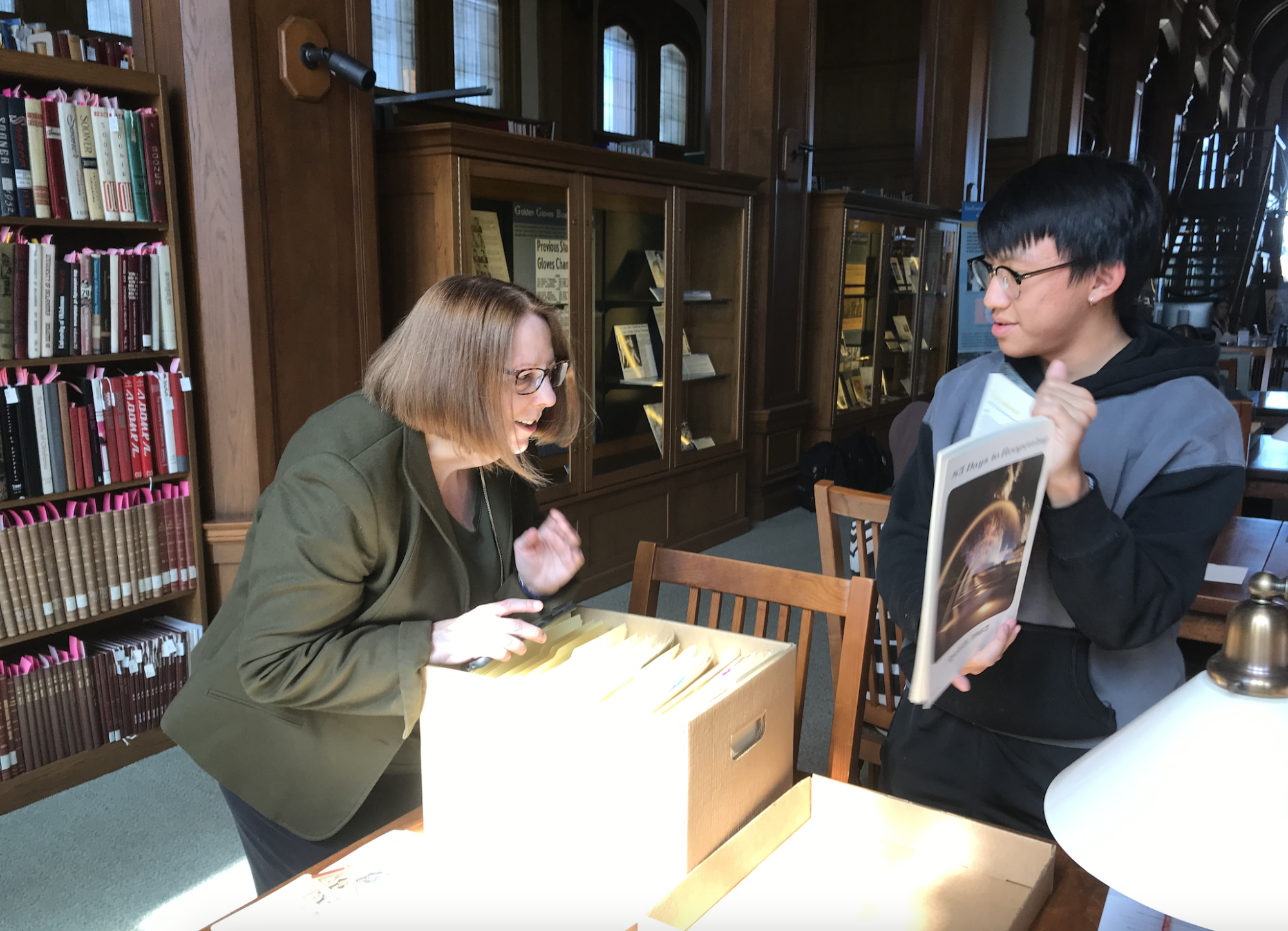 student and professor looking at a book