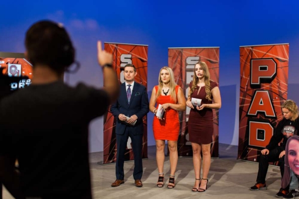 Three students standing on set of Sooner Sports Pad