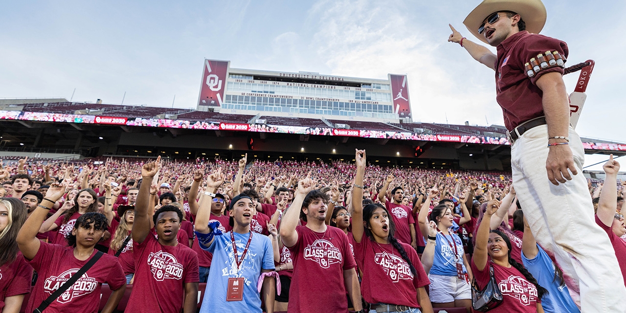 Students from the class of 2027 hold a crimson sign that says "Largest Class in OU's History" while celebrating Class Kickoff, held at the Gaylord Family - Oklahoma Memorial Stadium.