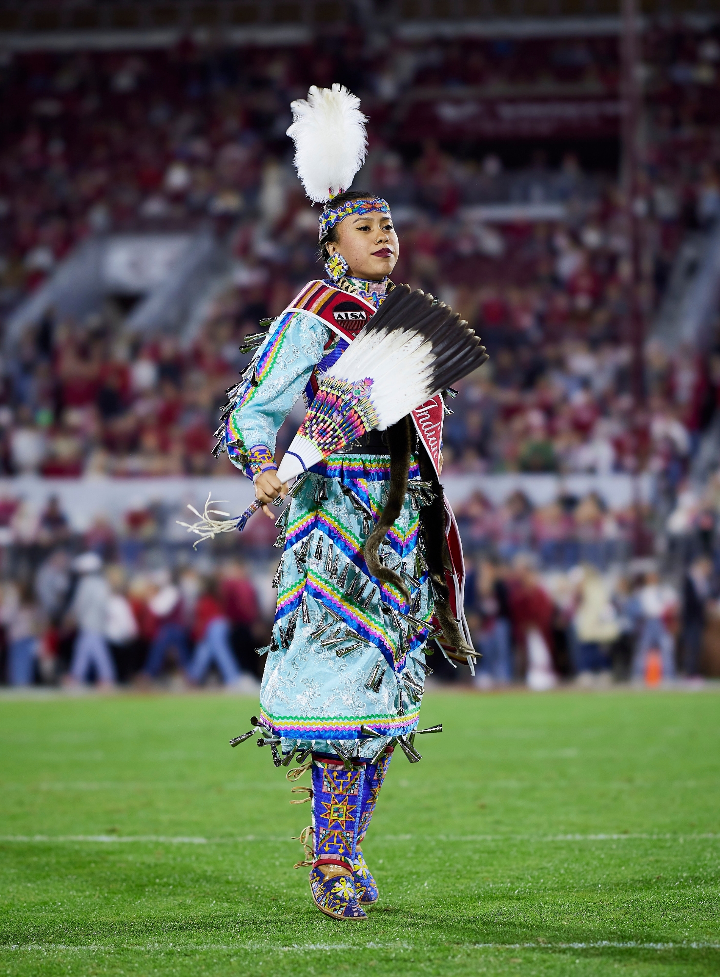 Miss Indian OU on football field in full regalia 