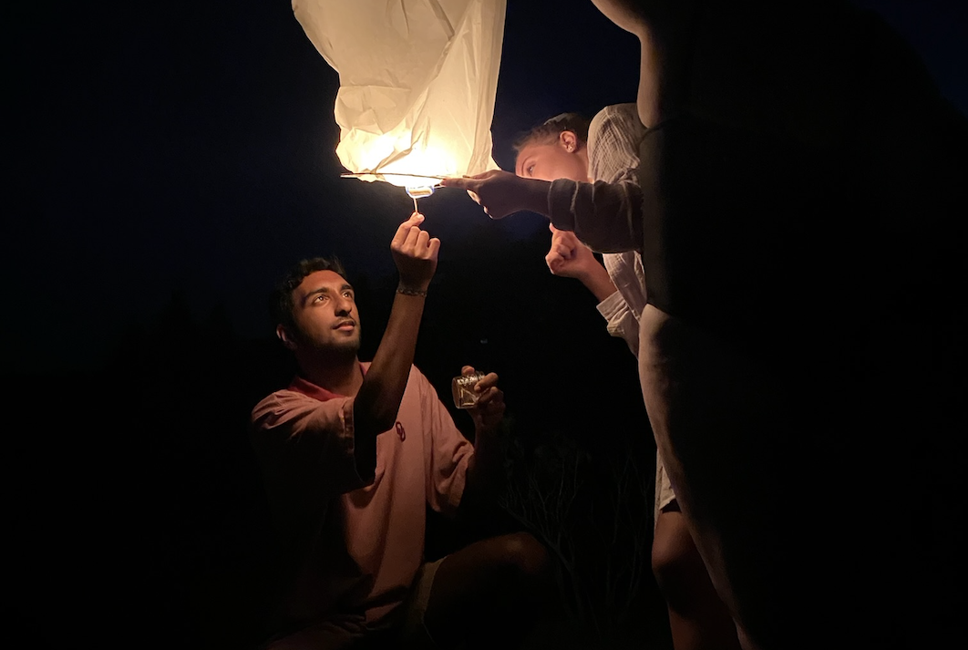 Andrew Jacob lighting a lantern in the dark with his colleagues from his internship.