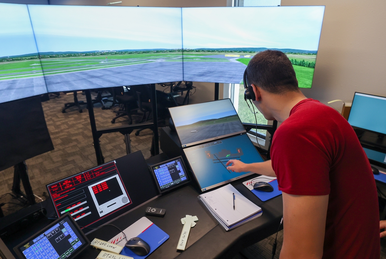 An aviation student working on multiple screens during class.