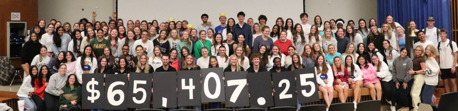 OU Dance Marathon committee members holding individual numbers to represent $65,407.25.