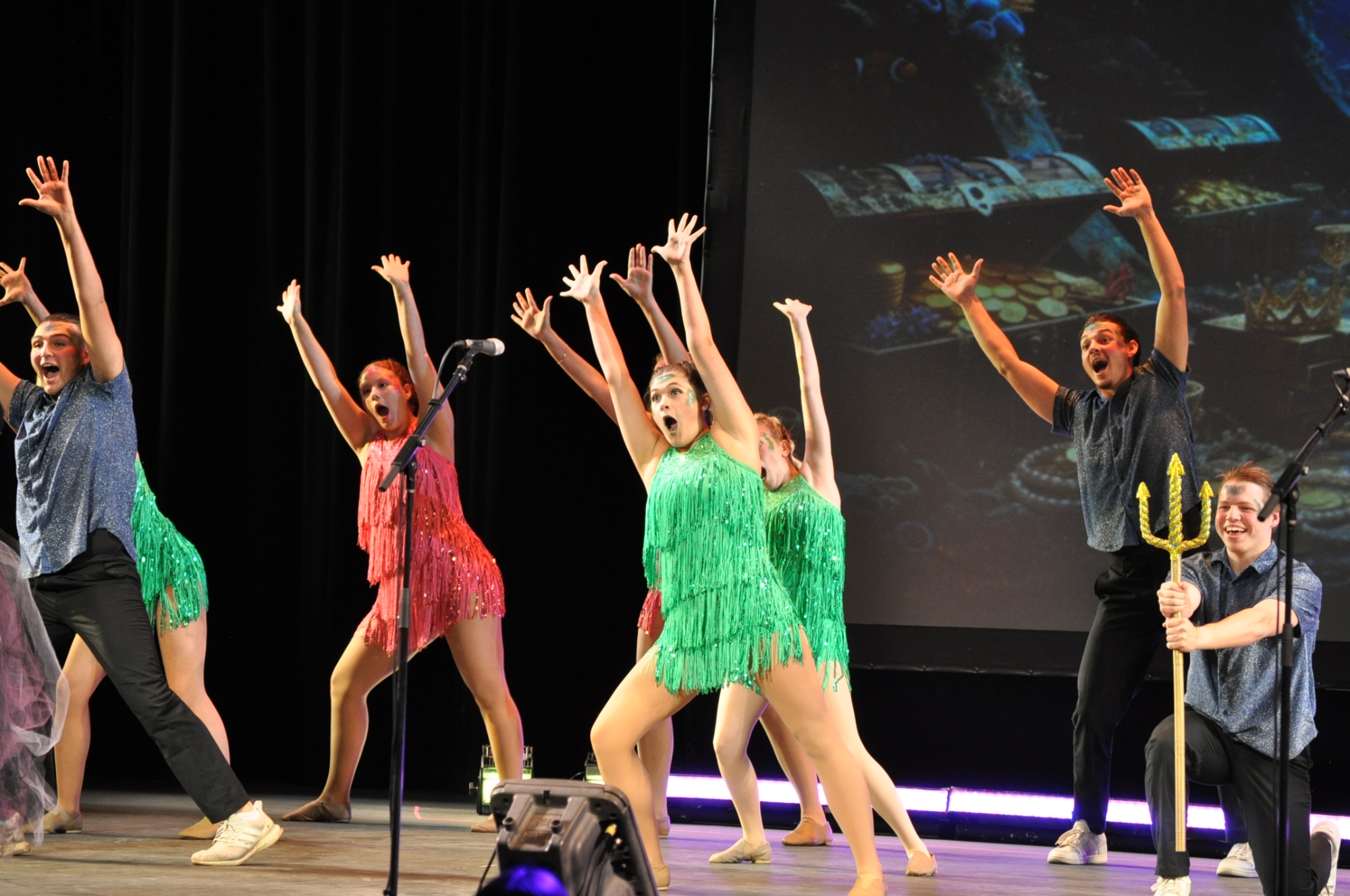 Students performing a mermaid-inspired act on stage. 