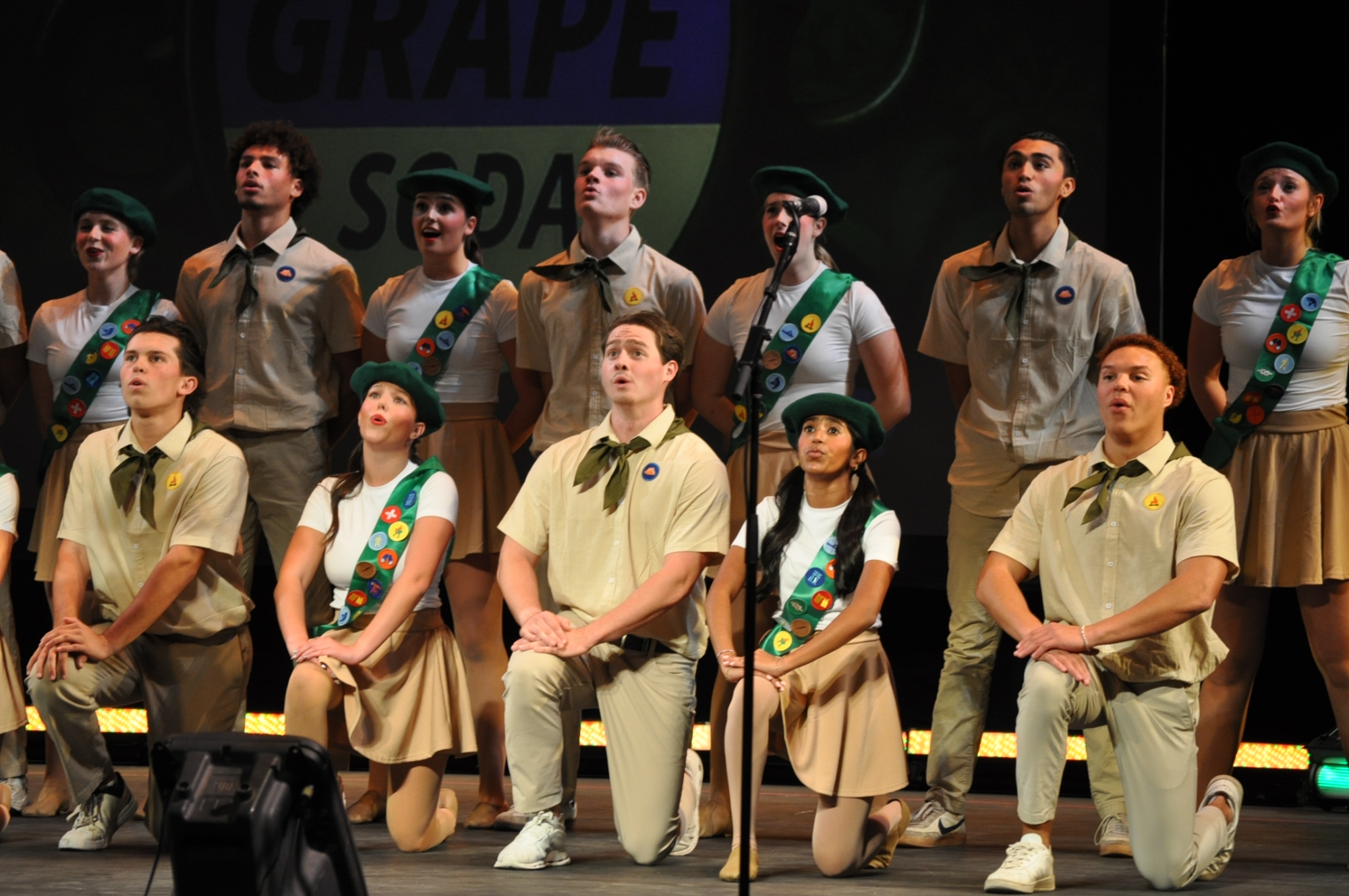 Students performing in uniforms from Boy Scouts and Girl Scouts. 