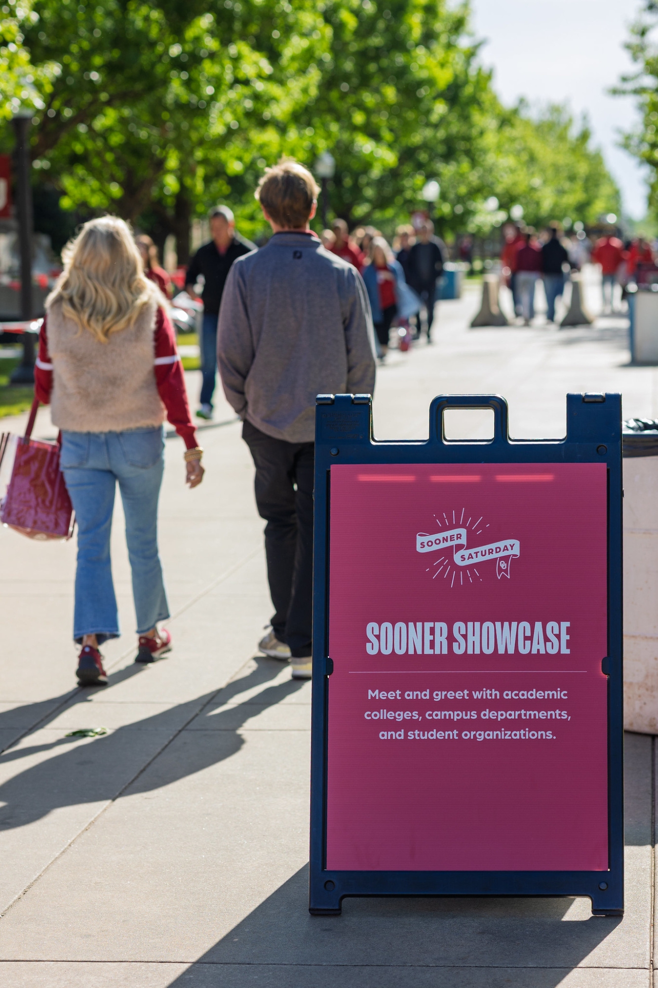 Sooner Saturday visitors walking past a "Sooner Showcase" sign.