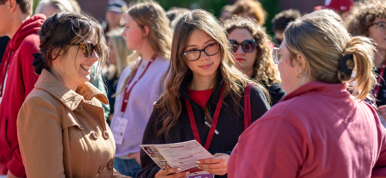 Student and their supporter connecting with OU staff at Sooner Saturday.