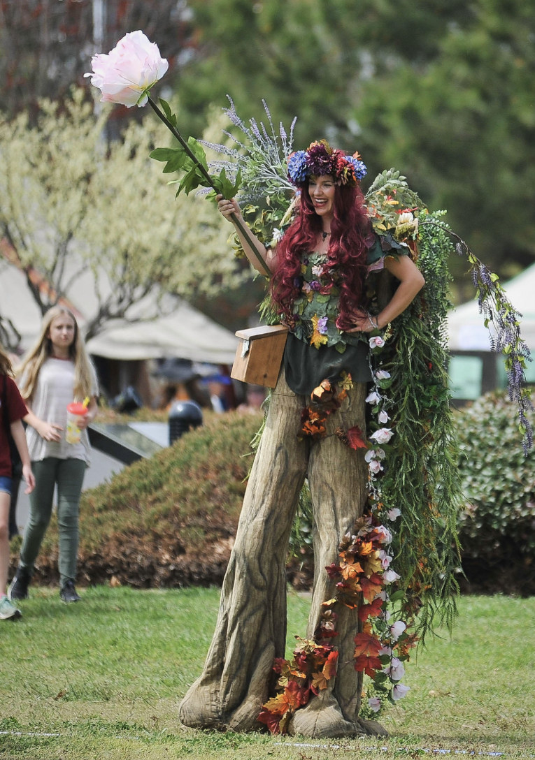 Mariah Menzie dresses as Mother Earth, a tall red-headed figure, during the Medieval Fair.