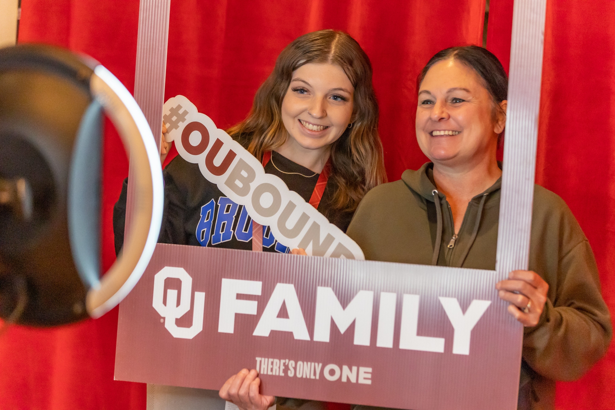 Parent and student holding OU Family sign