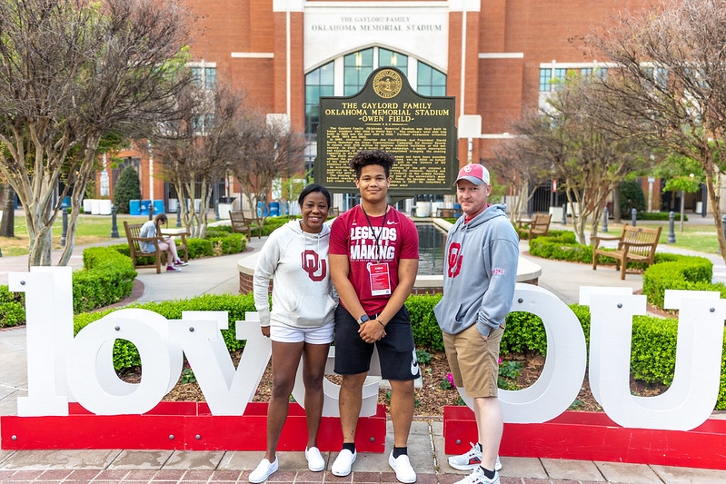Family in front of love OU sign