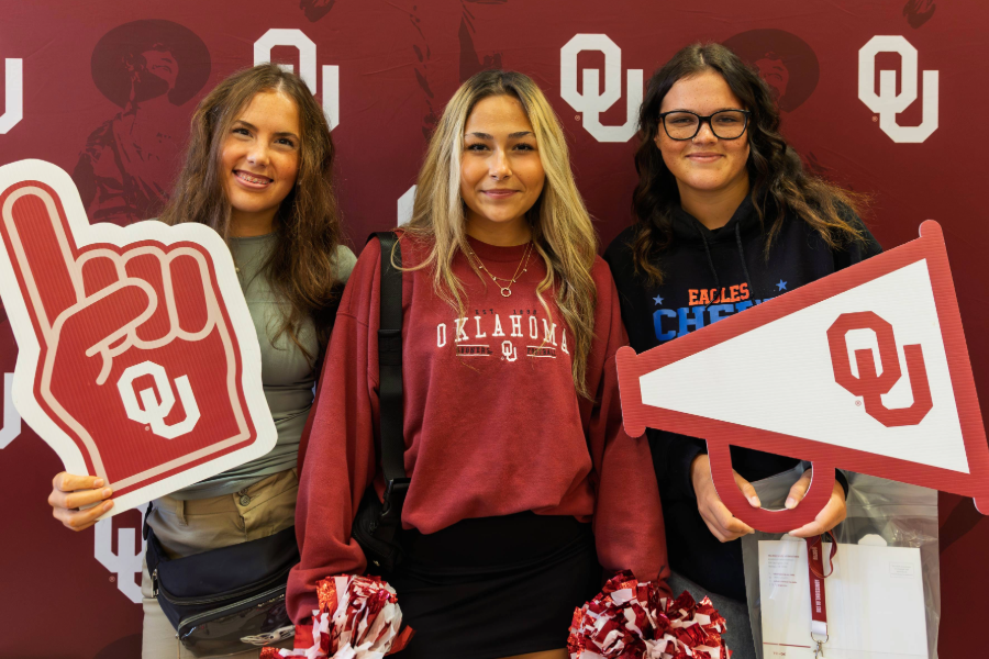 Three students posing in front of OU Background at Sower's day