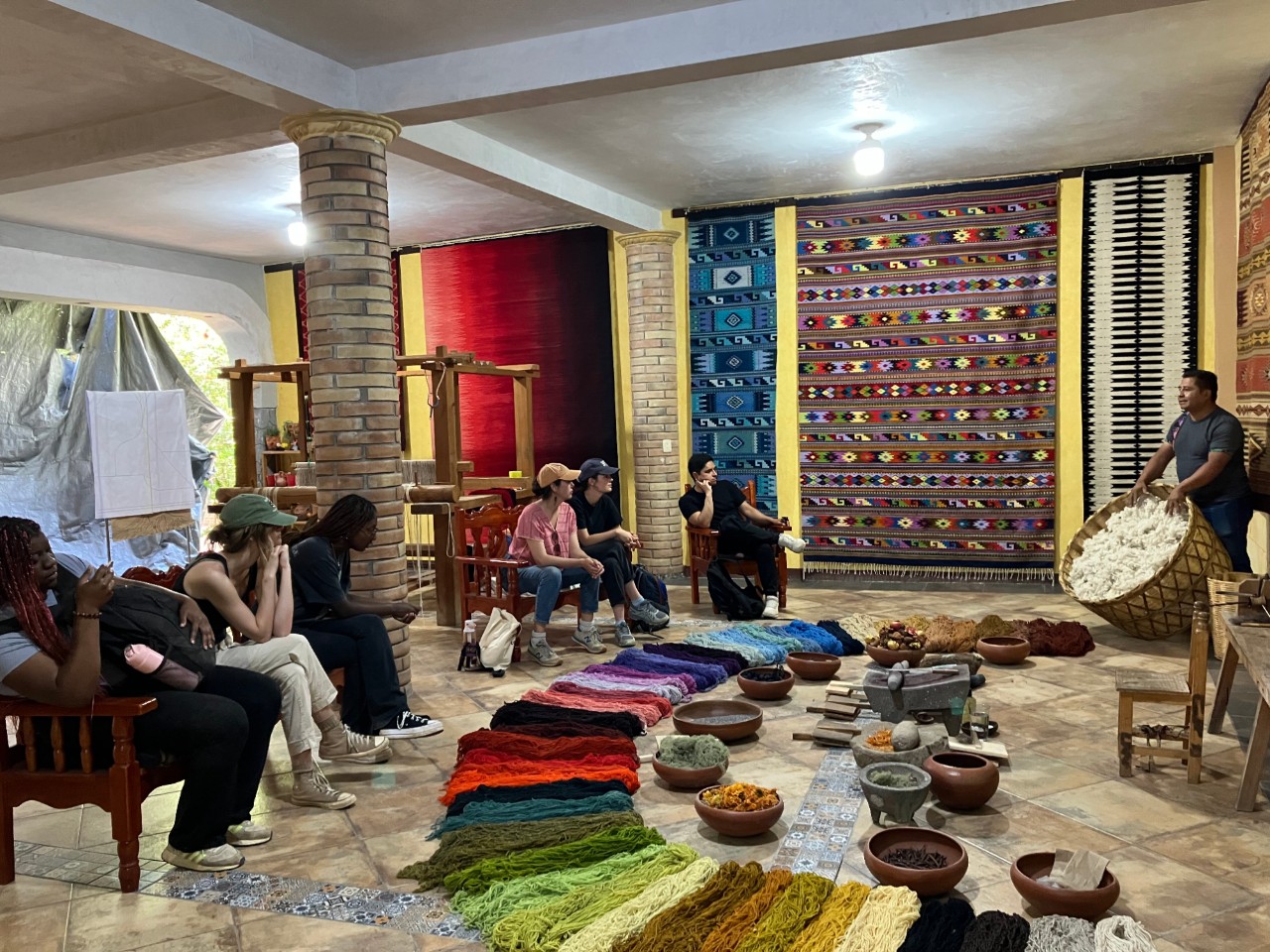 Students look at colorful textiles.
