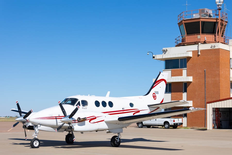 King Air C 90 B aircraft in front of a control tower.