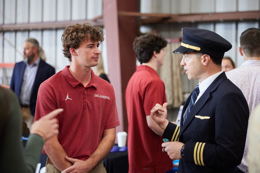 An aviation student talking to an airline pilot.
