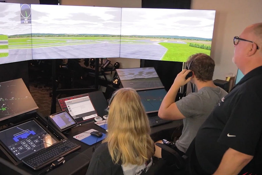 An airplane with a propeller in front of an air traffic control tower.