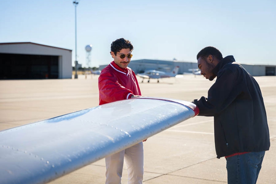 O U Aviation students looking at an airplane wing.