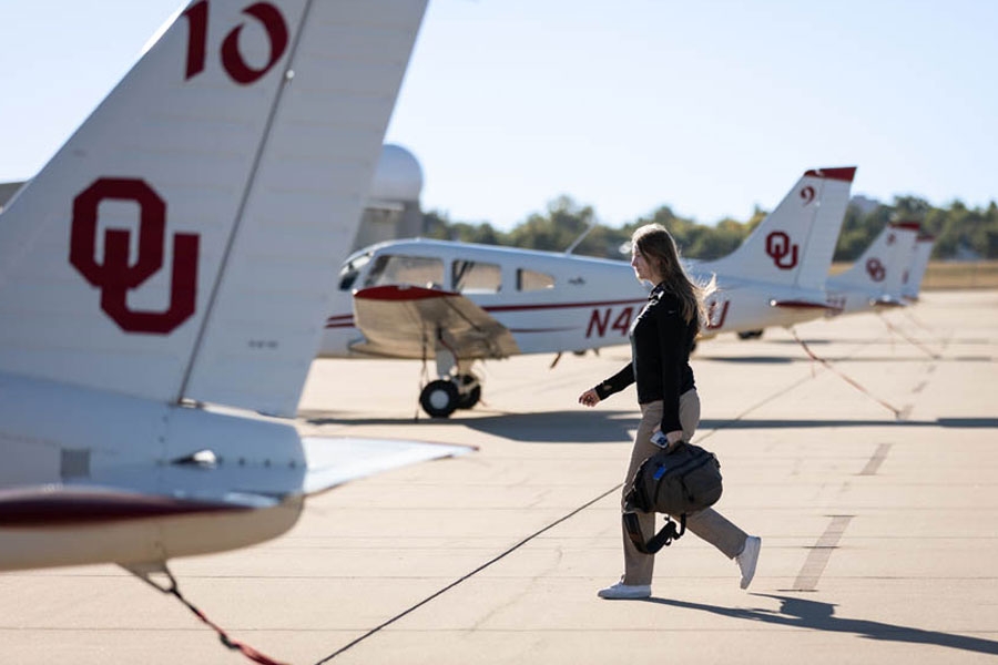 A person walking in front of a Warrior III aircraft.