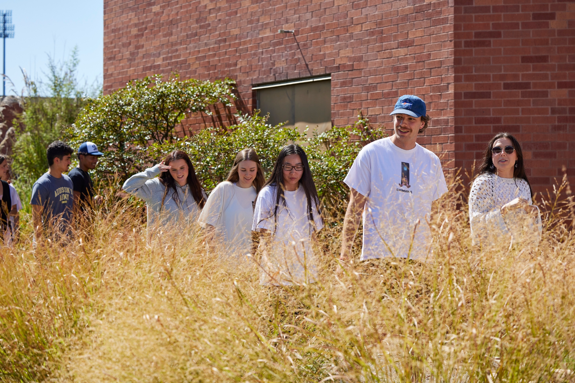 Students walking in a butterfly garden.