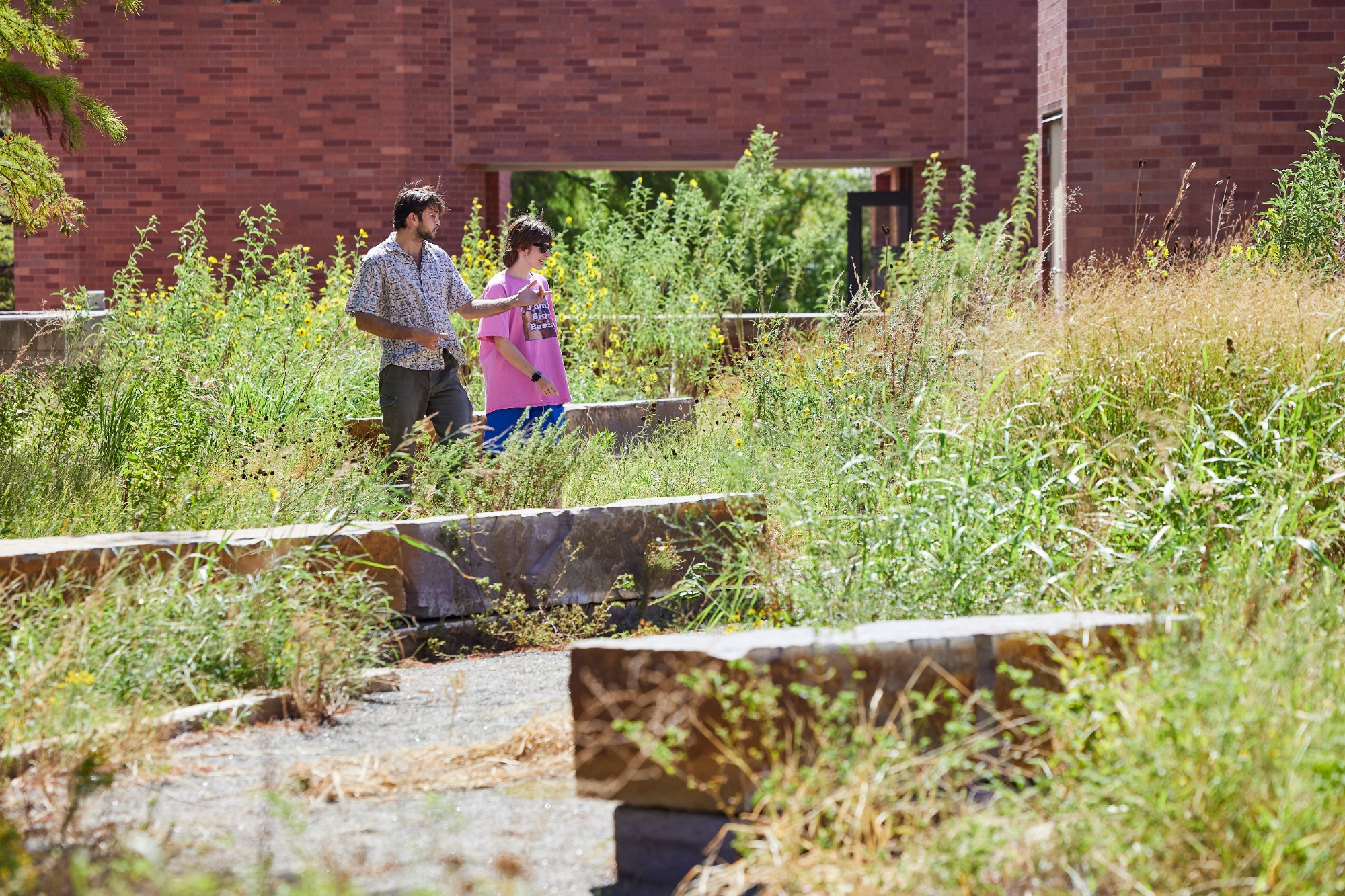 Students walking in a butterfly garden.