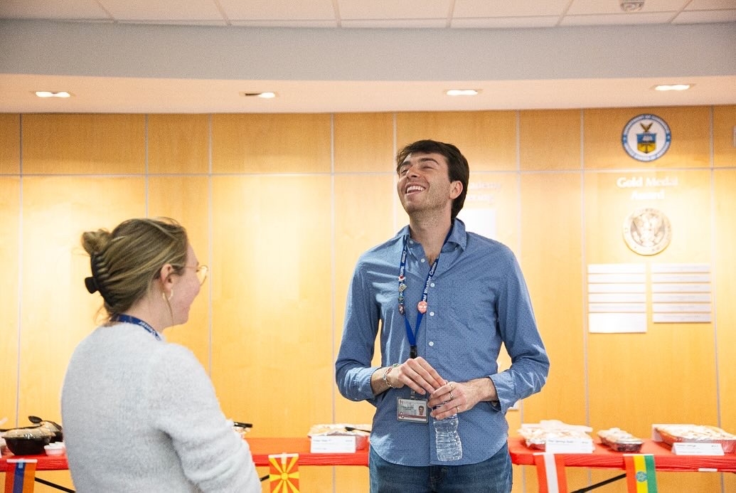 Two people attending the 2024 AGS Multicultural Festival, standing in front of tables of food.