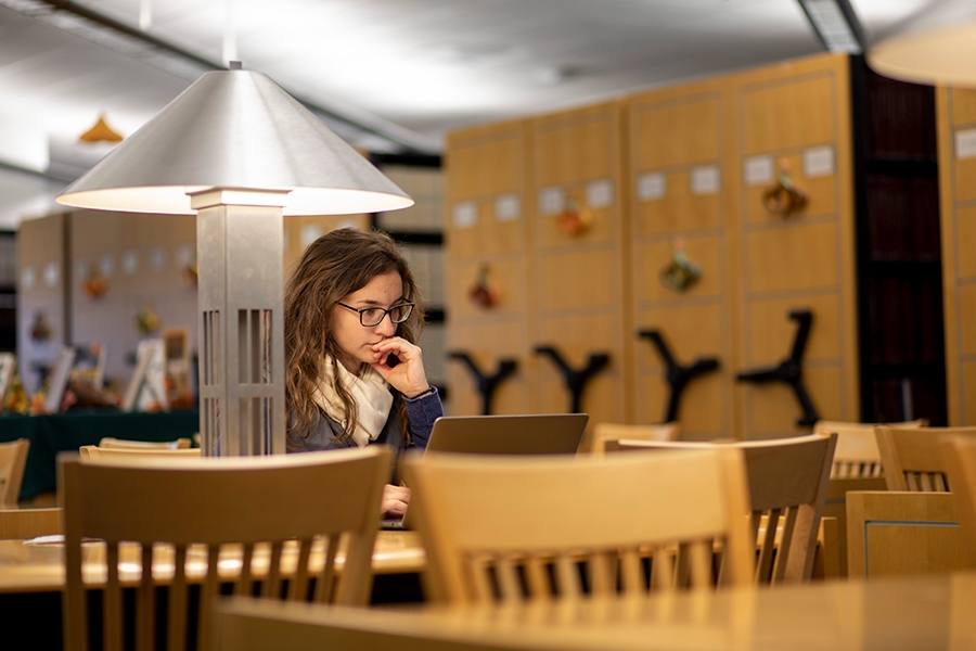 A student sitting at a table in the National Weather Center Library.