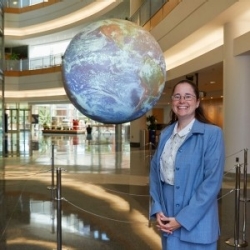 Dr. Amy McGovern pictured in front of the National Weather Center Science on a Sphere.