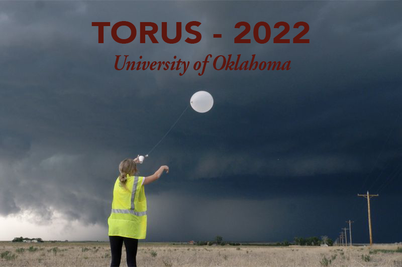 TORUS - 2022 the University of Oklahoma,  a person releases a weather balloon with a dark gray sky looming in the background.