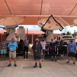 OU and NOAA personnel stand in front of radar trucks at the National Weather Center.