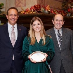 Andjela Jovanovic picturedin the center holding her Outstanding Senior Plate with OU president Joeseph Harroz and A&GS Dean Berrien Moore III on either side of her shoulders.