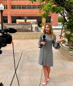 Hannah Gard reporting news in-front of Sarkeys Energy Center