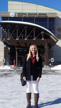 Tabitha Kloss in front of the National Weather Service Water and Weather Forecasting building in Alaska. National Weather Service Water and Weather Forecasting.