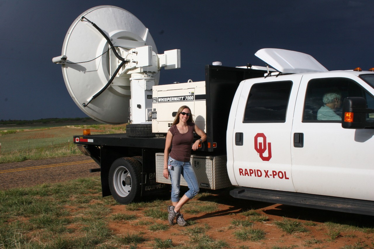 Jana Houser standing in front of an OU Rapid X-Pol radar truck. Whipserwatt 7000. OU Rapid X-Pol.