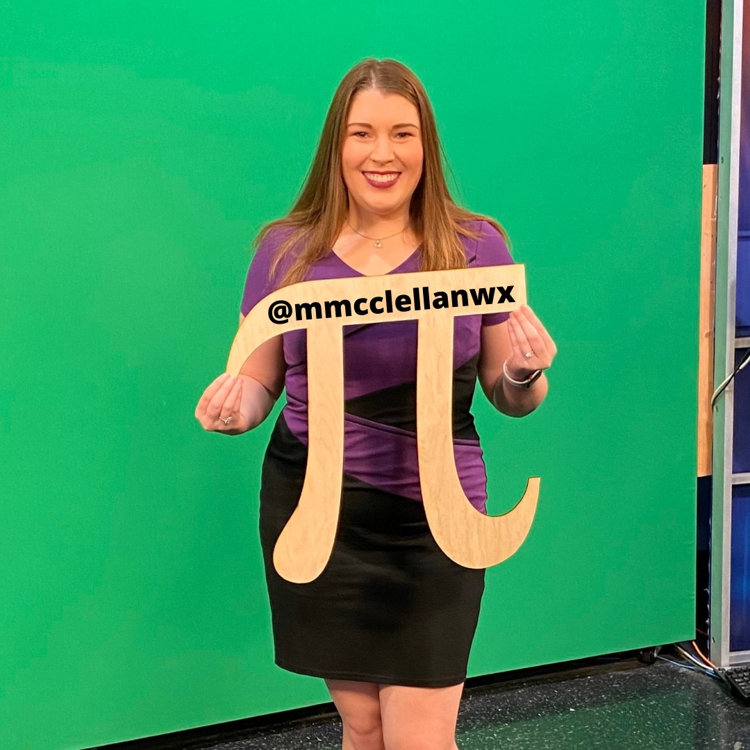 Megan McClellan holds a Pi symbol featuring her social media handle @mmcclellanwx.