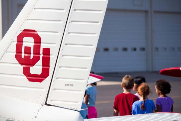 Sooner Flight Academy Students near the Tail of an OU Airplane