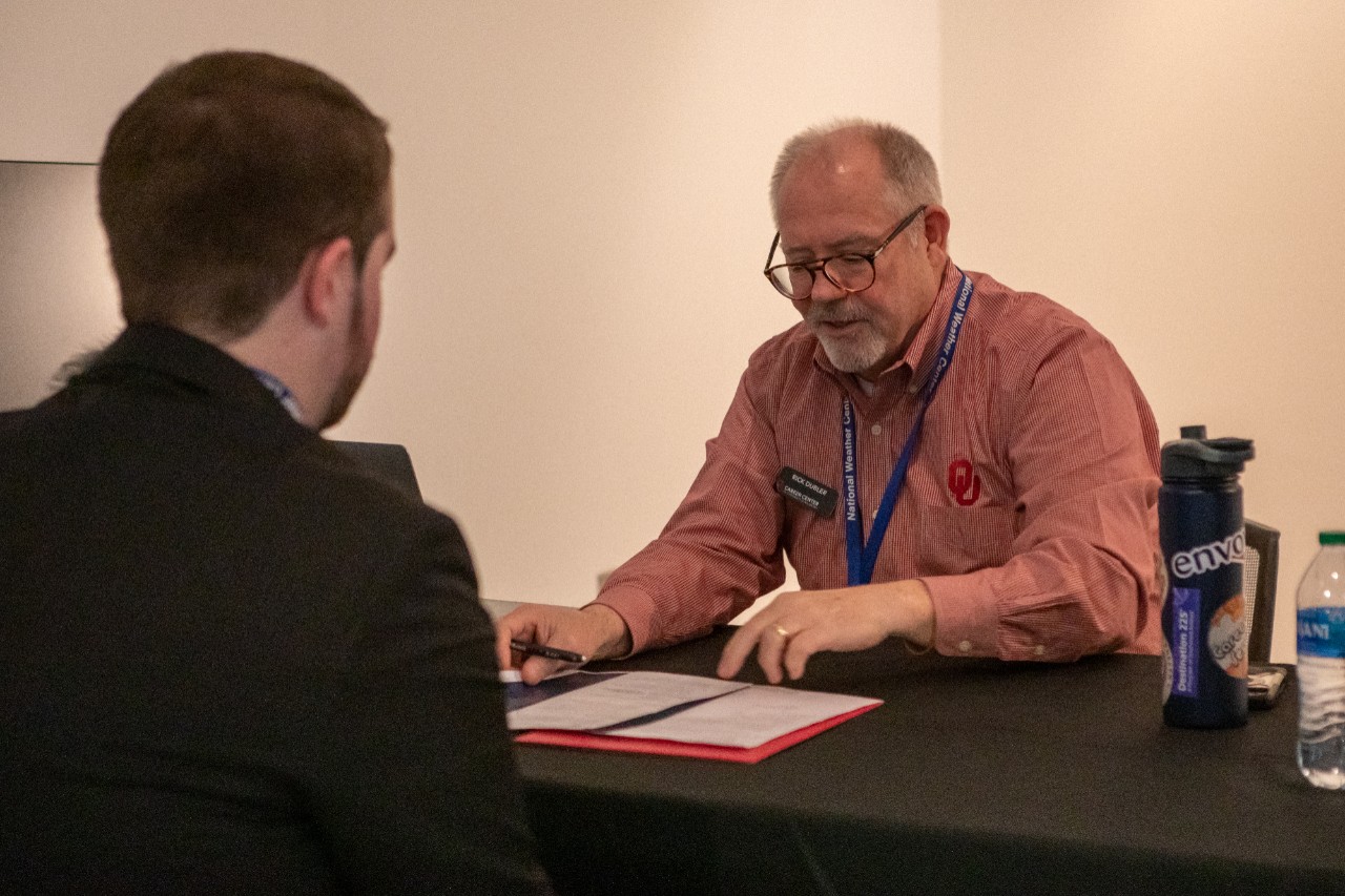 An advisor from the OU Career Center reviews options for a student at the 2023 A&GS career and internship fair. 
