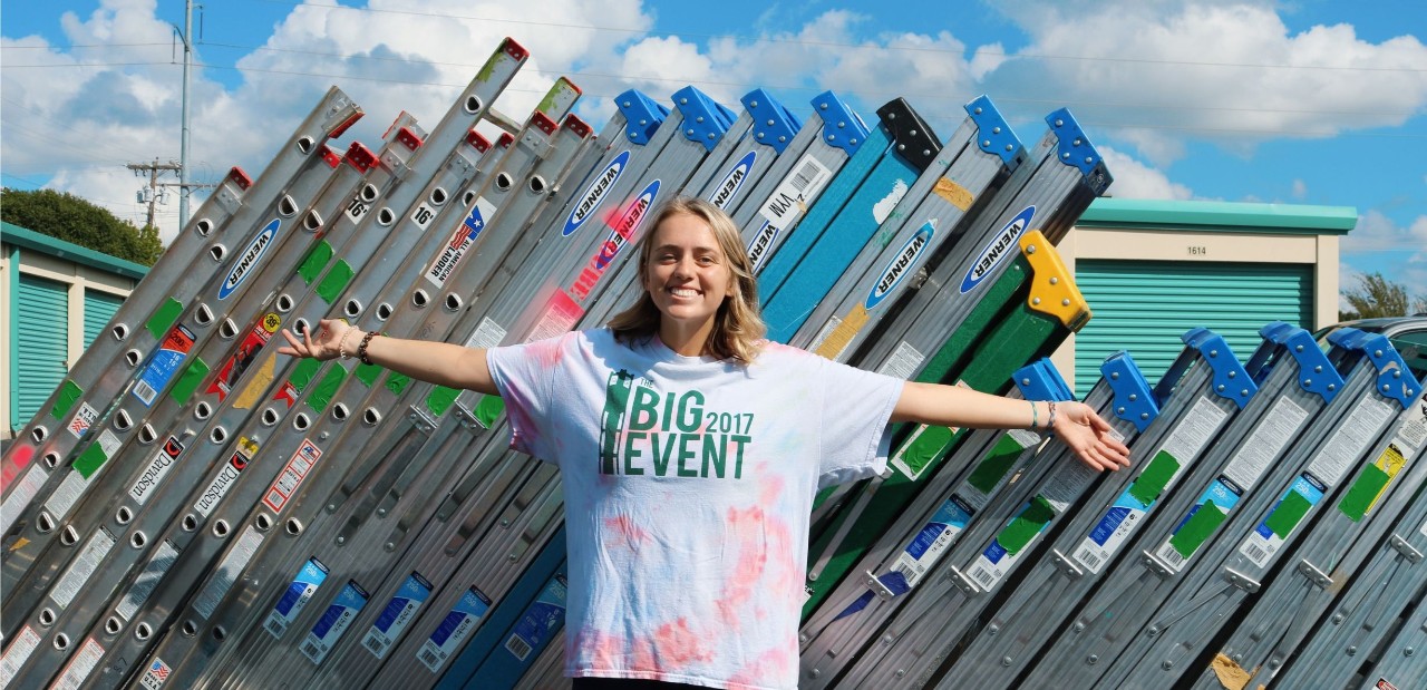 A student stands in front of ladders at the 2017 Big Event.