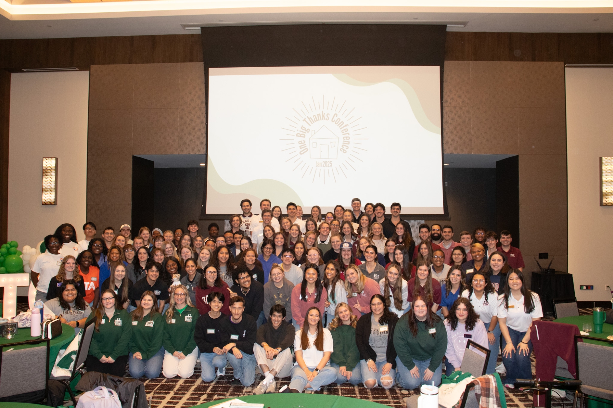 A group photo of many students in front of a projection screen.