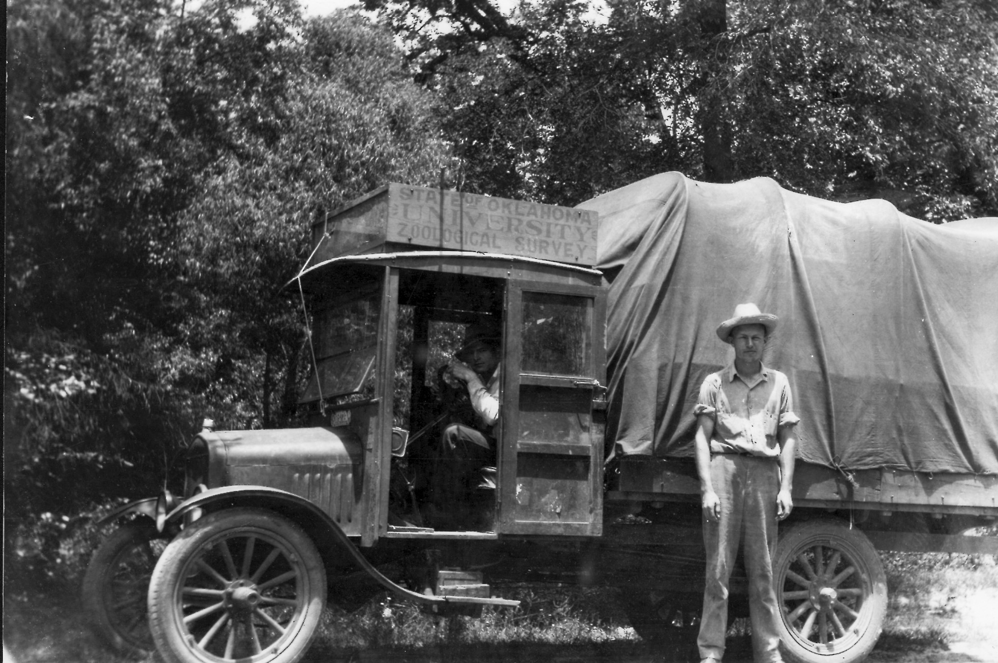 Two biologists with an old truck with sign saying "State of Oklahoma University Zoological Survey."  Part of the Ortenburger expeditions in the 1920's.