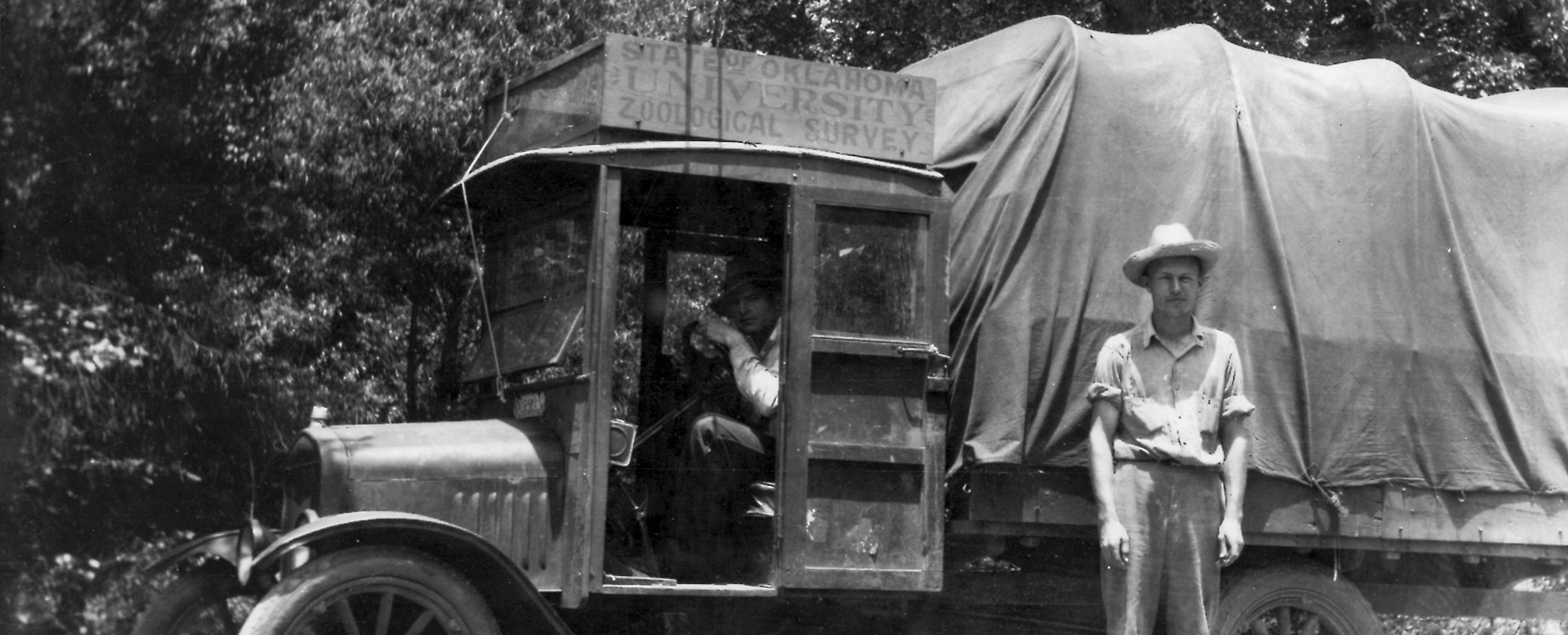 Two biologists with an old truck with sign saying "State of Oklahoma University Zoological Survey."  Part of the Ortenburger expeditions in the 1920's.