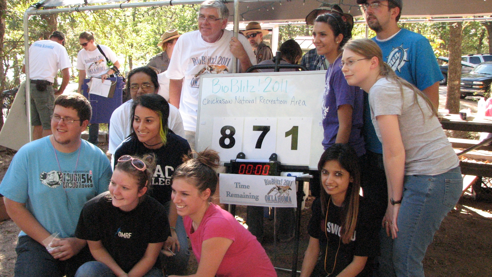 Group of community scientists around the 2011 BioBlitz! OK tally board that announces 871 species found.