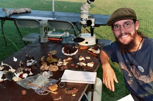 Student with notebook and a diversity of fungi on a table.