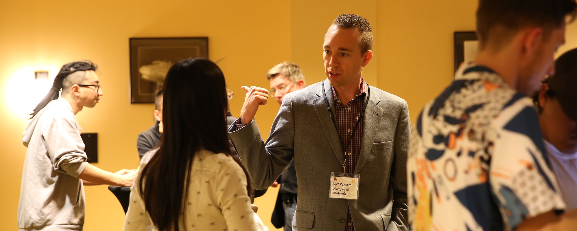 A man in front of a projector pointing upwards.  