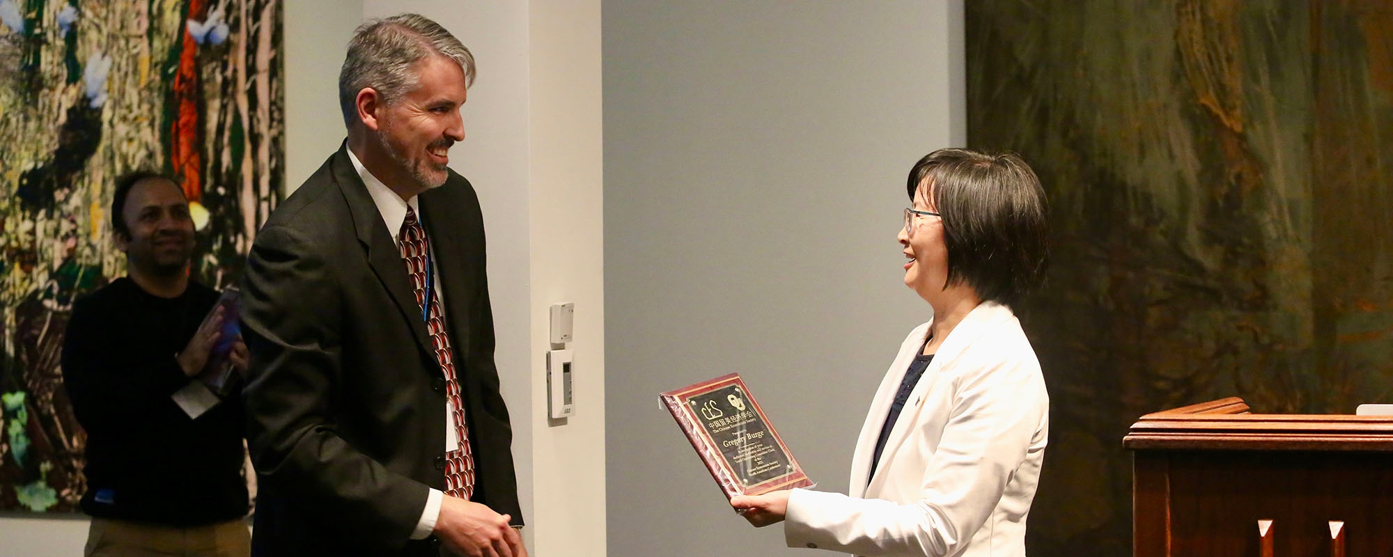 A man in front of a projector pointing upwards.  