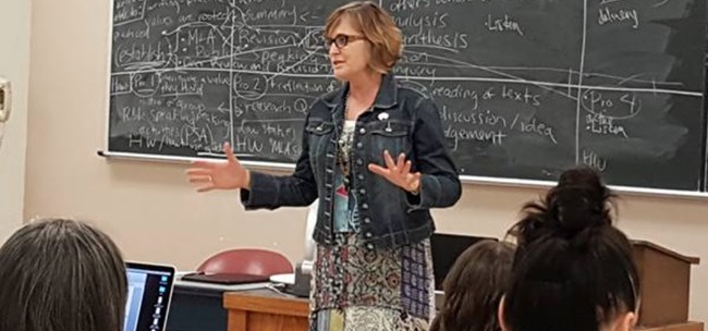 image of an instructor in front of a blackboard